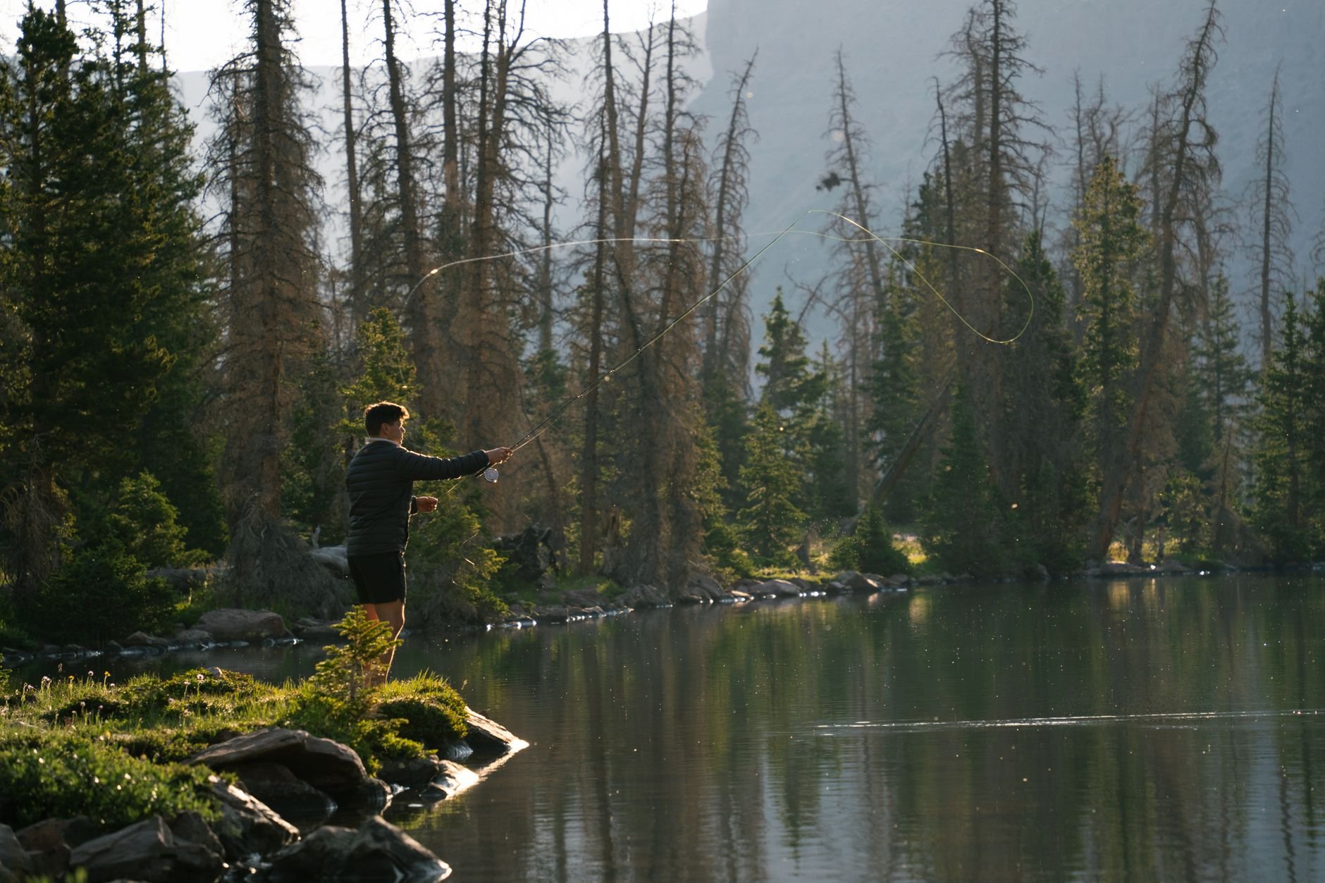 Fly fisherman casting in a mountain river at dawn in East Tennessee